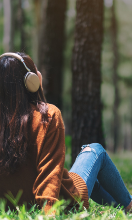 Mujer escuchando audios relajantes en el parque