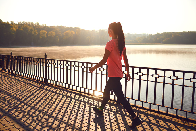 Mujer joven caminando al aire libre para evitar piernas hinchadas