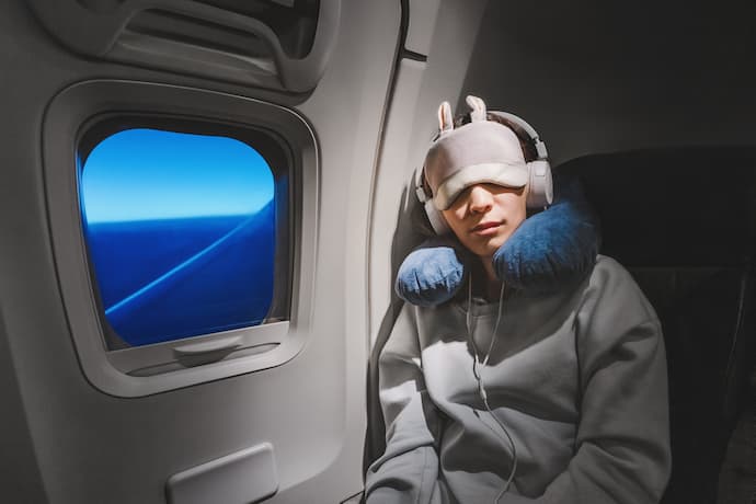 hombre con los síntomas del jet lag durante un vuelo