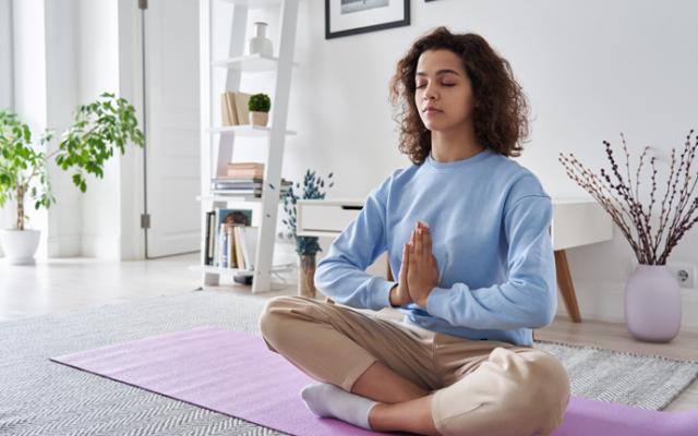 Mujer meditando la sala de su casa