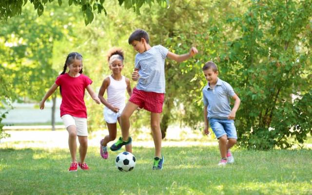 niños jugando fútbol al aire libre