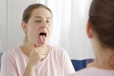 Mujer se revisa lengua